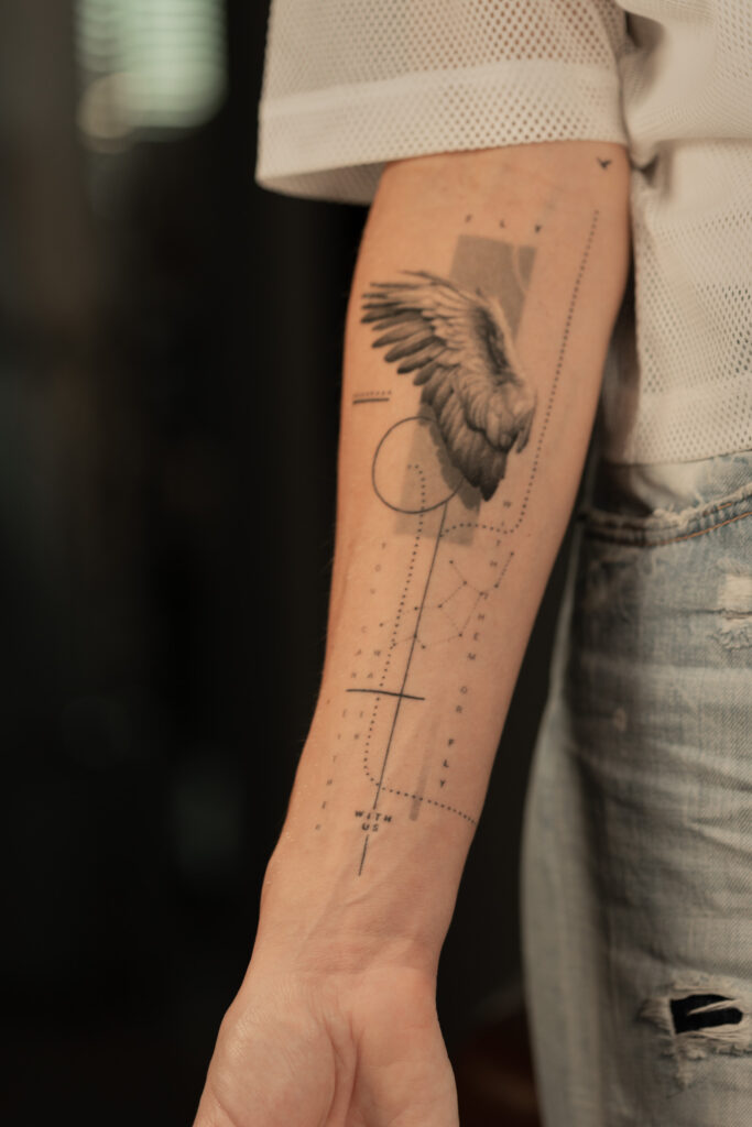 1 year 10 months healed tattoo - Wing and Typography Composition - Inner forearm - Vytautas Tattoo